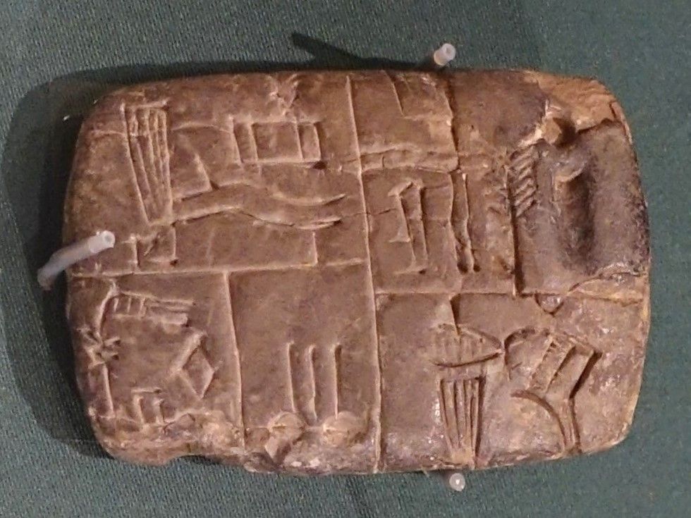 Tablette d'argile proto-cunéiforme couverte d'encoches de comptage et de pictogrammes